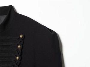 Detail of woven braid trim and antique bronze metal buttons on a black military jacket