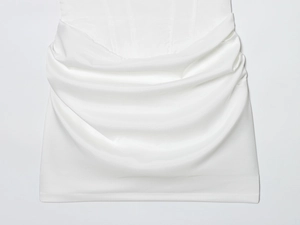 Detail van de witte gebreide jurk met horizontale gedrapeerde plooien en subtiele glans