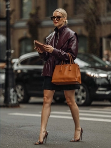 Detail of a burgundy faux leather jacket with lapel collar and stylish lantern sleeves