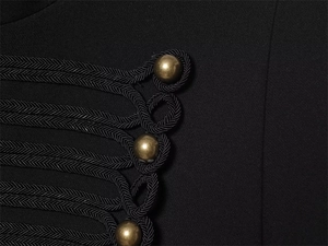 Detail of military-style black blazer featuring braided rope loops and antique gold buttons