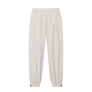 Detail of checkered light jogger pants featuring elastic cuffs and black button accents