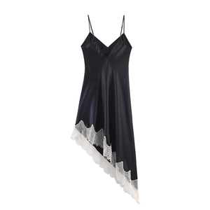 Detail of black satin dress featuring asymmetric white lace trim hem and V-neckline