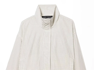 Close-up detail of light beige plaid nylon jacket with stand collar and hidden buttons