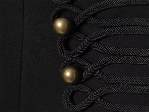 Detail of military style black jacket featuring woven rope loops and antique bronze buttons