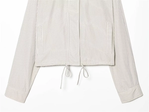 Detail of checkered jacket featuring adjustable drawstring hem and side pockets