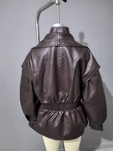 Detail view of the back of a brown faux leather jacket with wide elastic waistband