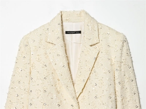 Detail of tweed texture with silver sequins and floral patterns on women's blazer