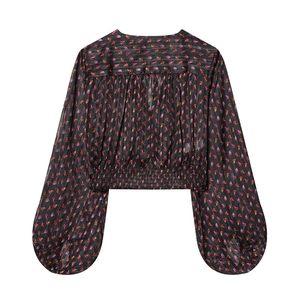 Detail of V-neck floral print crop top with elastic waist and lantern sleeve texture