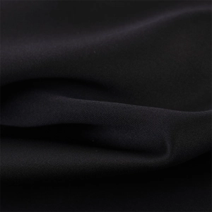 Dettaglio macro del tessuto di raso nero con trama liscia e lucentezza morbida elegante