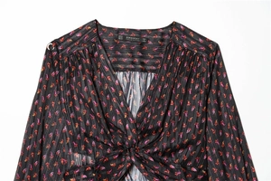 Detailed view of V-neck floral blouse with silver metallic stripes and front knot
