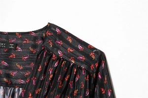 Detail of V-neckline and shoulder with small floral print and jacquard fabric texture