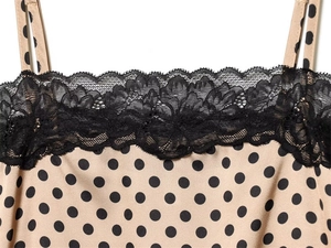 Close-up of polka dot dress featuring delicate black floral lace trim and spaghetti straps
