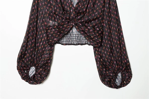Detail of V-neck twist front and vintage floral print on a black chiffon crop top