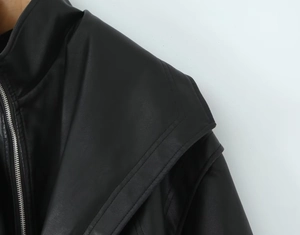 Detail of faux leather jacket shoulder featuring silver zipper and layered stitching texture