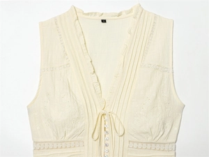 Détail du haut sans manches à col en V avec dentelle et broderie florale délicate