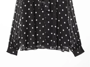 Detailed view of polka dot chiffon fabric with elegant neck tie and sheer long sleeves