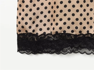 Detailed close-up of polka dot dress hem featuring elegant black floral lace trim