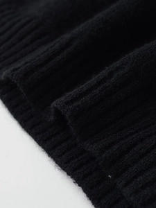 Dettaglio del tessuto a maglia a coste nere con trama ricca e motivi a linee verticali