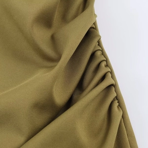 Detail of olive green knit fabric with elegant pleated texture and draped finish