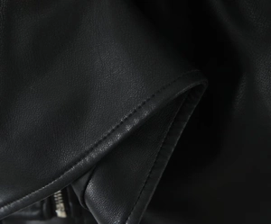 Detail of premium black faux leather jacket showing fine texture and neat stitching work
