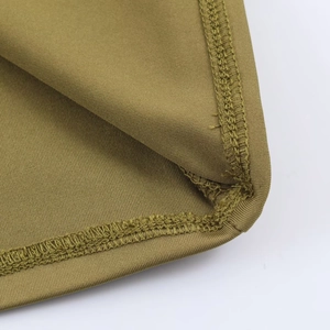 Macro shot of olive green knit dress detailing double-stitched hem and fine fabric texture