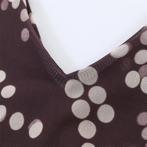 Macro detail of V-neckline on polka dot mesh top with fine stitching and breathable fabric