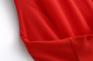Detailed macro shot of red dress fabric showing expert pocket stitching and smooth texture