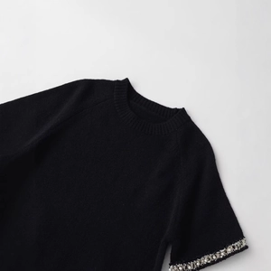 Maglia nera a maniche corte in maglia con polsini decorati con perle e strass