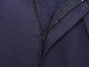 Détail de la fermeture éclair en nylon et des coutures sur un pantalon bleu marine