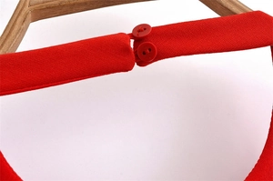 Detail of red sleeveless dress neckline featuring a secure double button closure design