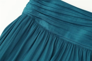 Close-up of elegant peacock blue satin skirt with fine pleats and pleated waistband