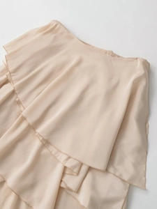 Detailed view of beige layered ruffle skirt fabric with delicate chiffon pleated texture