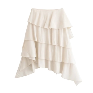 Dettaglio di gonna a balze color crema con volant asimmetrici in tessuto di chiffon