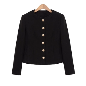 Detail of black tweed jacket featuring textured fabric and decorative gold metal buttons