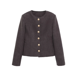 Close-up of dark grey tweed texture and golden metal buttons on the elegant round neck jacket