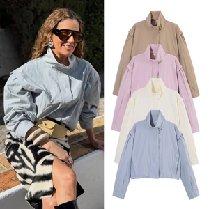 Detail of loose fit high neck jackets in pastel blue, cream, pink, and khaki colors