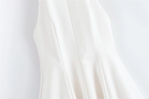 Close-up of elegant princess seams and tailored waistline on a white sleeveless dress