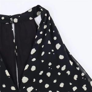Close-up of halter high neck with polka dot print and button back cutout detail