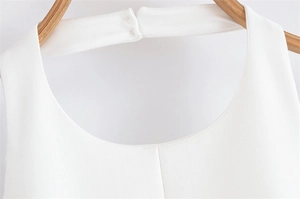 Detail of white sleeveless halter neckline with fine stitching on a wooden hanger