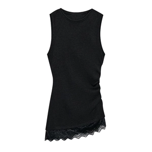 Detailed close-up of the black ruched sleeveless top with elegant lace trim at the hem