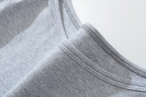 Detailed close-up of fine flatlock stitching on grey boat neck t-shirt cotton fabric