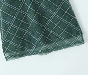 Gros plan du tissu écossais vert montrant le motif à carreaux et la texture légère