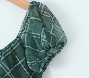 Détail de la robe en résille à carreaux verts avec manches bouffantes et poignets élastiques
