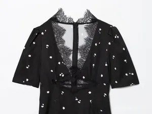 Close-up of deep V-neckline with delicate black eyelash lace trim and floral print