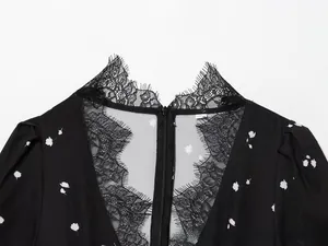 Close-up of V-neckline featuring delicate black eyelash lace and floral fabric details