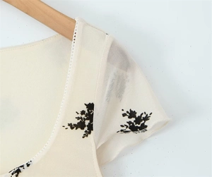 Close-up of floral dress shoulder with mesh flutter sleeves and delicate lace trim
