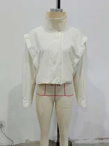 Detail of high neck beige jacket featuring unique ruffled shoulder accents and textured fabric