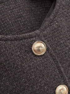 Close-up of charcoal tweed texture with gold embossed metal buttons on a suit jacket