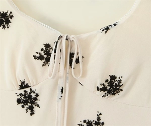 Detail of floral printed dress with delicate white lace trim and drawstring at the U-neck