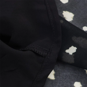 Detailed view of black polka dot chiffon splicing and neat stitching on dress seams